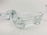 figurine de chien en verre transparent posée sur un socle blanc