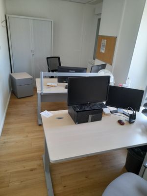 a desk with two computers and a laptop on it