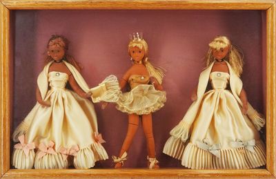 three dolls that are in a shadow box together