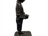 statue of a young boy holding a bird on a marble base