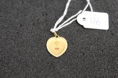 a gold heart shaped tag on a black surface