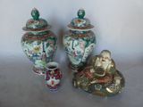 three asian vases and a buddha statue on a table