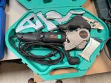 une boîte à outils verte contenant des outils, posée sur une table