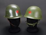 two green helmets with red stars on them sitting next to each other