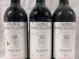 three bottles of red wine are lined up on a table