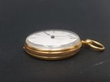 a gold pocket watch on a black surface