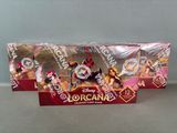 two disney figurines are sitting in a box on a table