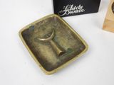 a small brass plate with a bull ' s head on it