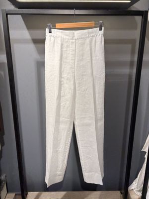 une photo d'un pantalon blanc suspendu à un portant