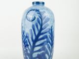 a blue and white vase sitting on a white surface