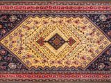 an oriental rug with a diamond design on a black ground