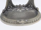 a silver plate on a stand on a white surface