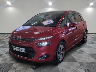 la voiture rouge est garée sur un sol en damier dans le garage