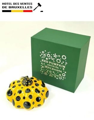 a yellow and black polka dot pumpkin next to a green box