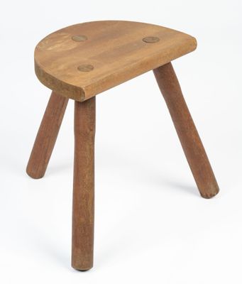 a small wooden stool with three legs on a white background