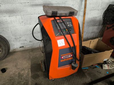 an orange machine that is sitting in a garage
