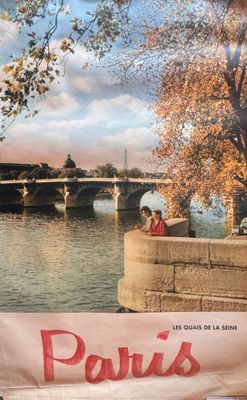 une affiche représentant un couple assis sur un banc au bord de l'eau