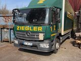 un camion vert garé sur un parking