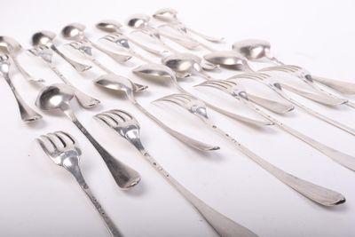 de nombreuses fourchettes et cuillères disposées sur la table
