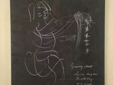 framed drawing of a man holding a knife in front of a blackboard