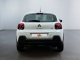the rear end of a white citrole parked in a white room