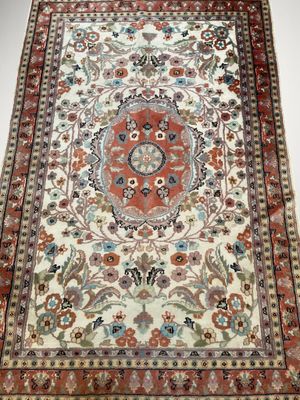 un tapis oriental avec un motif floral sur fond blanc