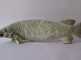 une statue de poisson posée sur une surface blanche