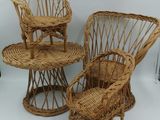 trois chaises en osier et une table sont disposées sur un fond blanc
