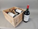 two bottles of wine in a wooden box next to a bottle of wine