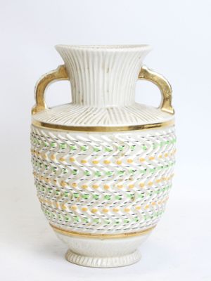 a white vase with a gold handle on a white background
