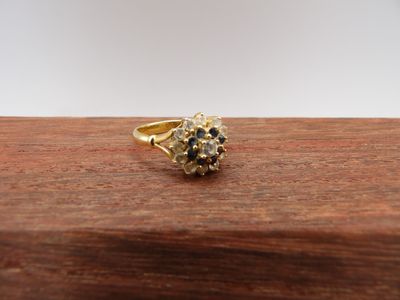 un gros plan d'une bague en or sertie d'un diamant bleu et blanc
