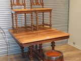 une table en bois avec deux chaises et un tonneau posé par terre