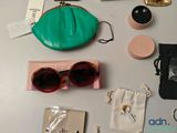 many items that are on the table including sunglasses, a purse, and other items