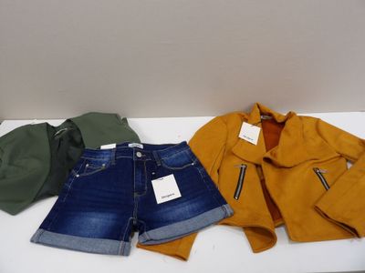 three pairs of shorts, a jacket, and a hat on a table