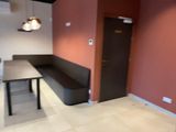 a table and a bench in a room with a red wall
