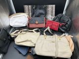 many bags and purses sitting on the back of an escalator