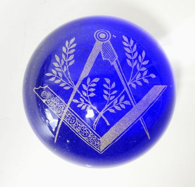 une image représentant une boule de verre bleue ornée d'un symbole maçonnique