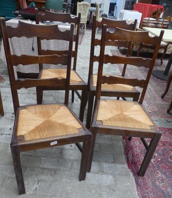 quatre chaises en bois disposées dans une pièce dont le sol est recouvert d'un tapis