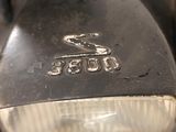 a close up of a motorcycle headlight with a logo on it