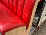 a red bench that is sitting in the back of a truck