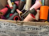 many spools of thread in a box on a table