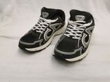 une paire de baskets noires et blanches avec des lacets blancs sur fond blanc