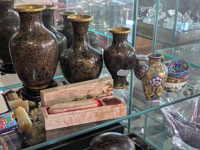many vases and bowls on display in a glass case