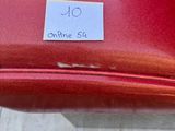 a red suitcase with a sticker on it sitting on the ground