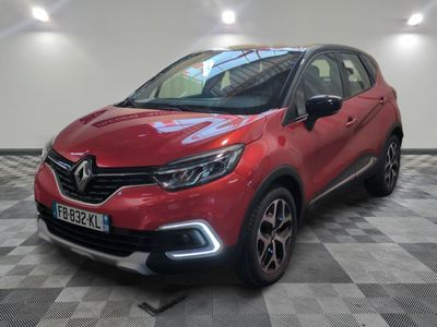 La voiture rouge est garée sur un sol carrelé à damier.