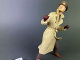 toy figurine of a man in a trench coat and hat holding a baseball bat