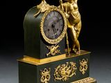 a gold and green clock with a statue on top