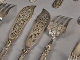 a lot of silver spoons and forks that are on a table