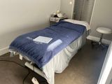 a bed with a blue blanket on it in a room