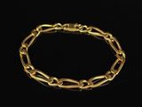 a close up of a gold bracelet on a black background